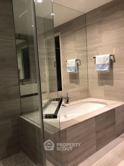 Luxurious modern bathroom with elegant bathtub and glass shower enclosure.