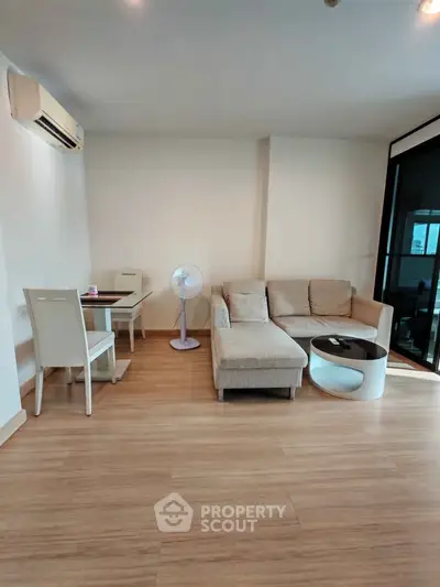Modern living room with cozy sofa and dining area, featuring sleek wooden flooring.