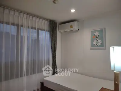 Cozy bedroom with air conditioning and soft lighting, perfect for relaxation.