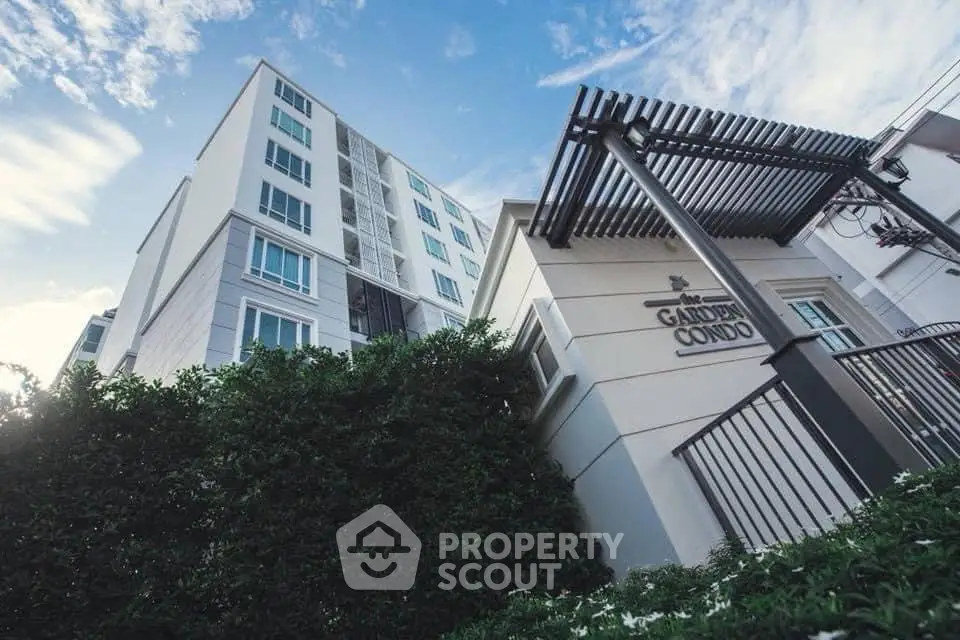 Modern condo building with lush greenery and stylish entrance