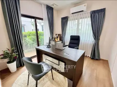 Modern home office with sleek desk, large window, and stylish decor