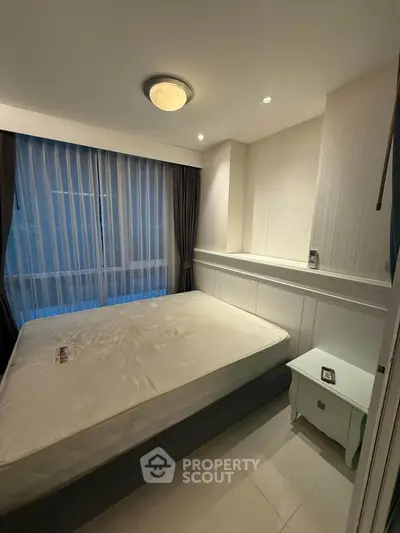 Cozy bedroom with large window and modern lighting in a stylish apartment.