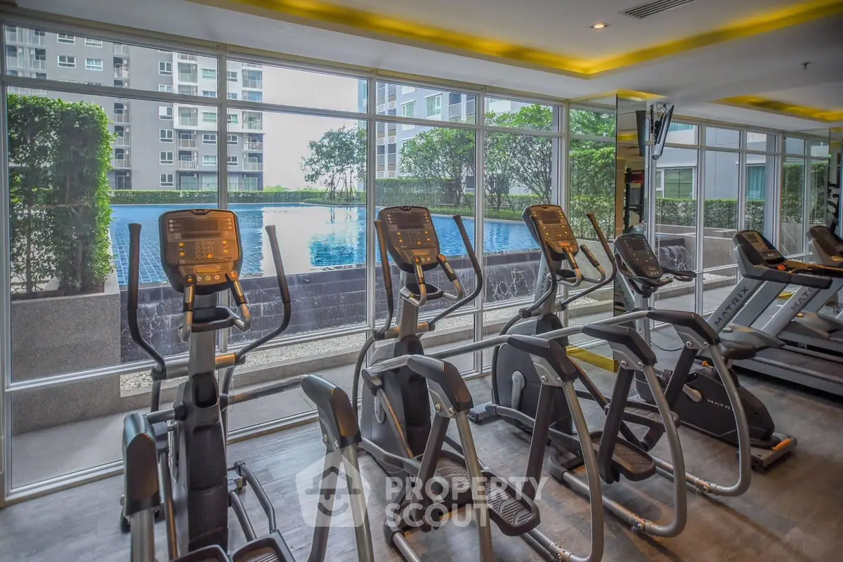 Modern gym with pool view in luxury apartment complex