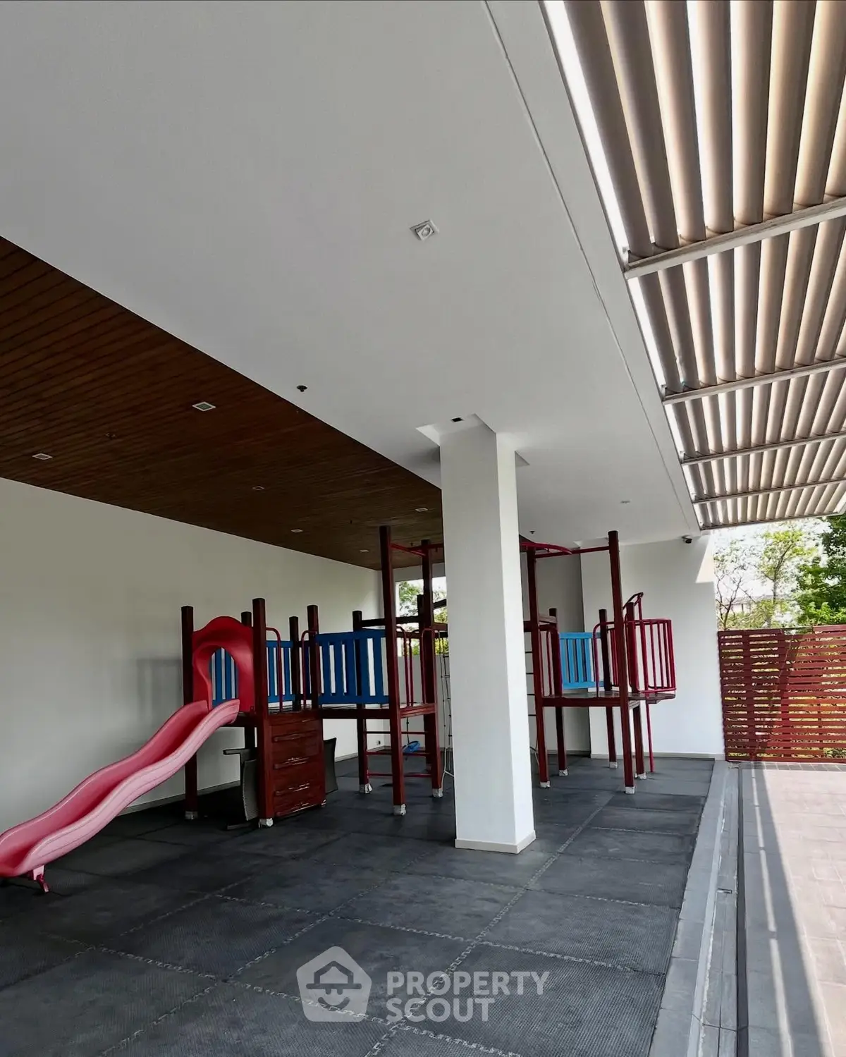 Modern outdoor playground area with sleek design and vibrant colors in a residential complex.