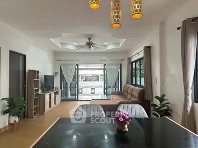 Spacious living room with modern decor and large windows opening to a garden view.