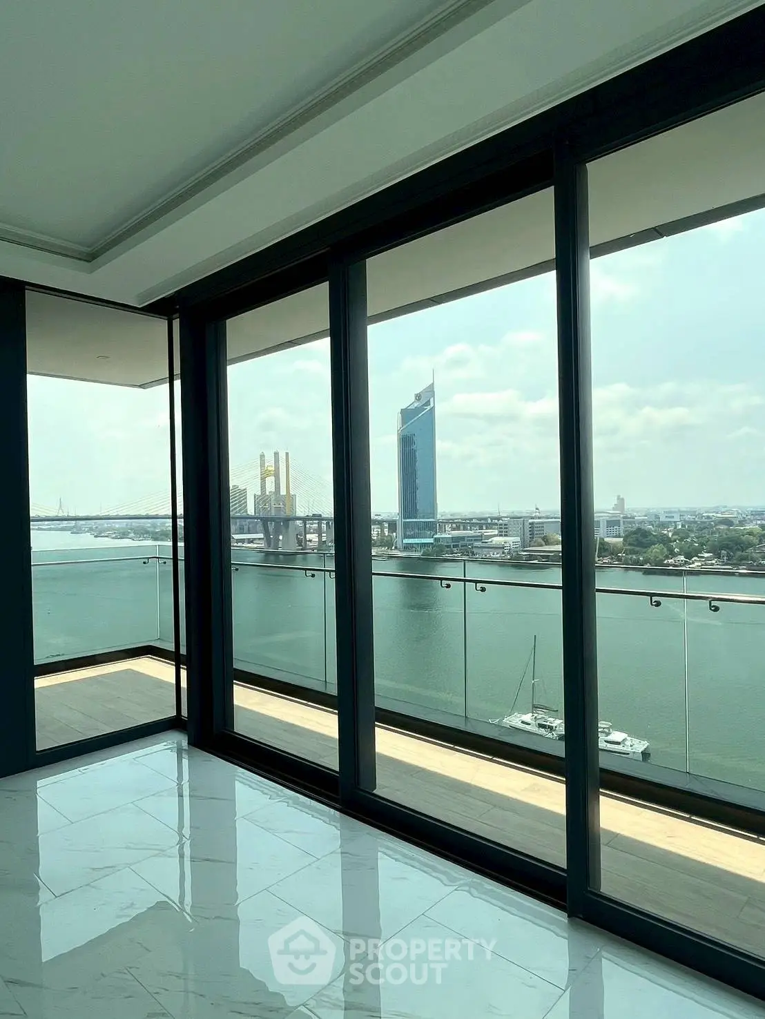 Luxurious waterfront apartment with stunning river views and floor-to-ceiling windows.