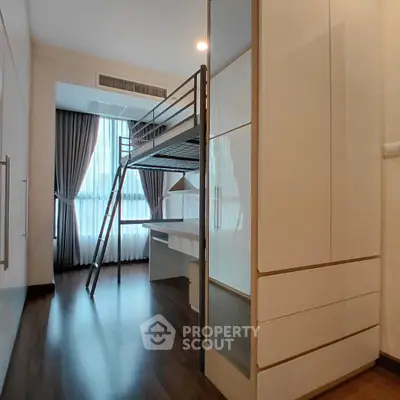 Modern bedroom with loft bed and study area, featuring sleek design and ample natural light.