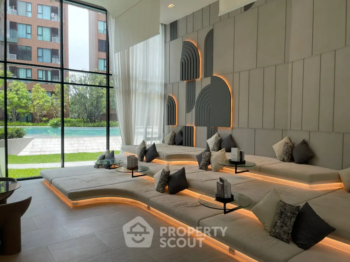 Luxurious modern living room with stylish seating and large windows overlooking a serene garden and pool.
