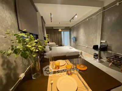 Modern studio apartment with stylish decor and open layout, featuring a cozy dining area and comfortable bed.