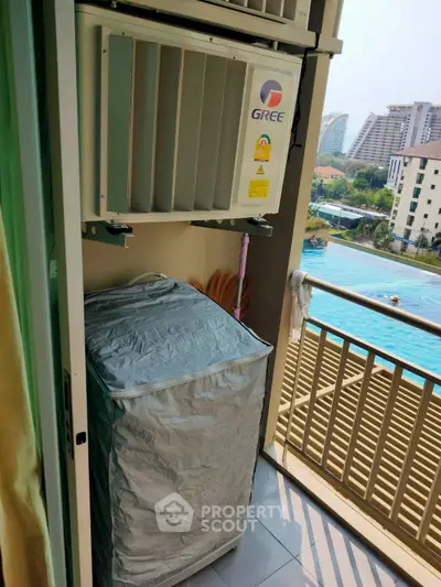 Cozy balcony with pool view and air conditioning unit in urban apartment