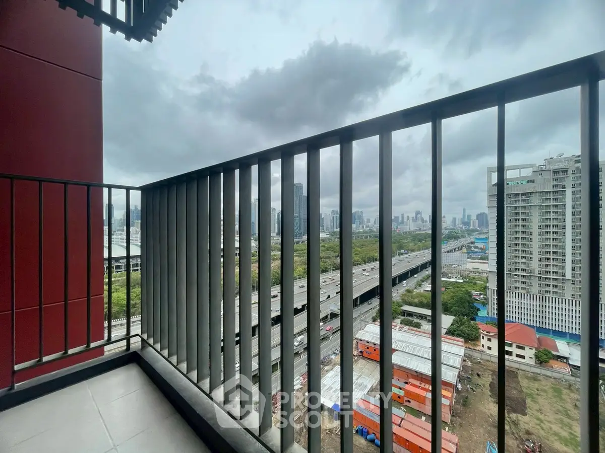 Stunning cityscape view from a modern balcony overlooking urban skyline and highway.