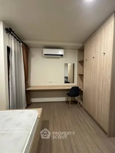 Modern bedroom with built-in wardrobe and air conditioning, featuring a sleek desk and chair for a cozy workspace.