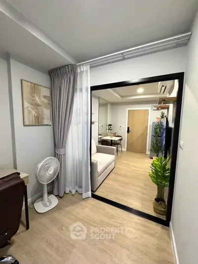 Modern living room with sliding glass door, stylish decor, and wooden flooring in a cozy apartment.