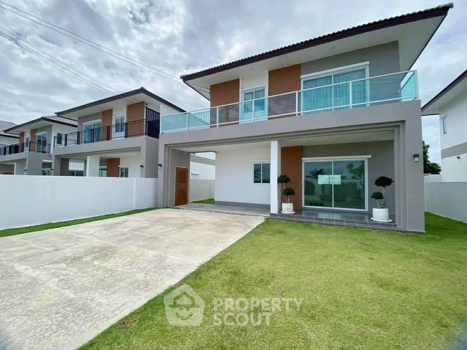 Modern two-story house with spacious driveway and manicured lawn in a serene neighborhood.