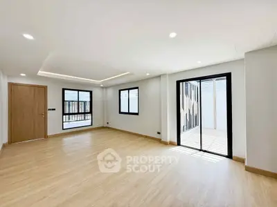 Spacious modern living room with wooden flooring and large windows