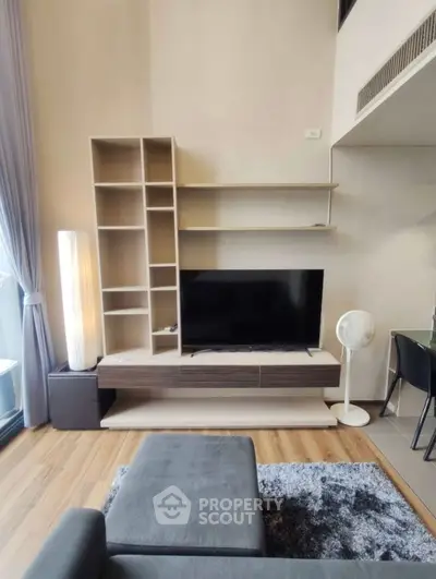 Modern living room with stylish shelving and flat-screen TV, featuring cozy seating and elegant decor.
