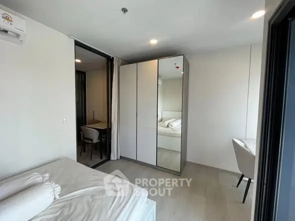 Modern bedroom with sleek wardrobe and study area in contemporary apartment
