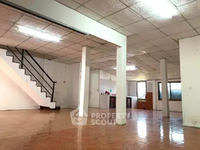 Spacious open-plan interior with tiled flooring and staircase, ideal for customization.