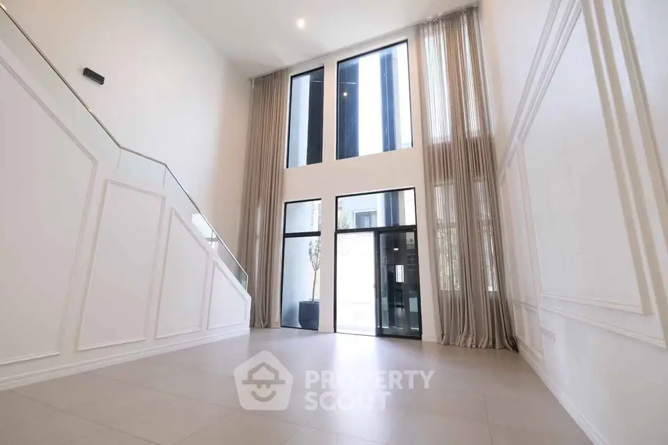 Spacious modern entrance with high ceilings and large windows in luxury property.