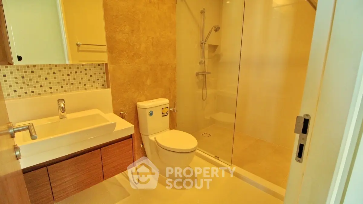 Modern bathroom with glass shower and stylish vanity in a contemporary home.