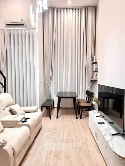 Modern living room with high ceilings, elegant curtains, and stylish furniture in a cozy apartment.
