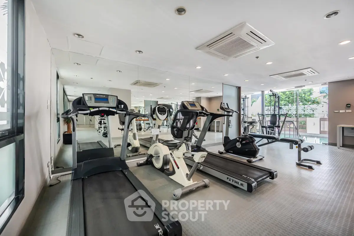 Modern gym with state-of-the-art fitness equipment and mirrored walls in a luxury apartment complex.