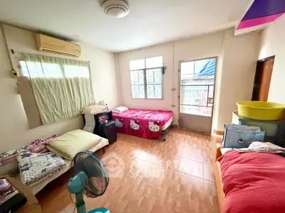 Cozy bedroom with twin beds and natural light, perfect for a comfortable living space.