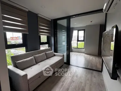 Modern living room with sleek design and large windows offering natural light and a view.