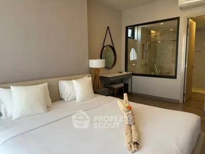 Luxurious bedroom with modern decor and ensuite bathroom, featuring elegant furnishings and ambient lighting.