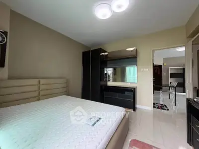 Spacious bedroom with modern furniture and ample natural light in a stylish apartment.