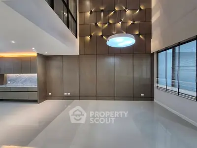 Spacious modern living room with high ceiling and elegant lighting