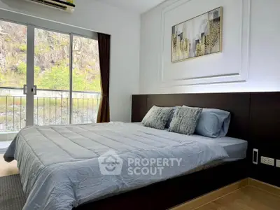 Modern bedroom with large window and scenic view, featuring stylish decor and cozy bedding.