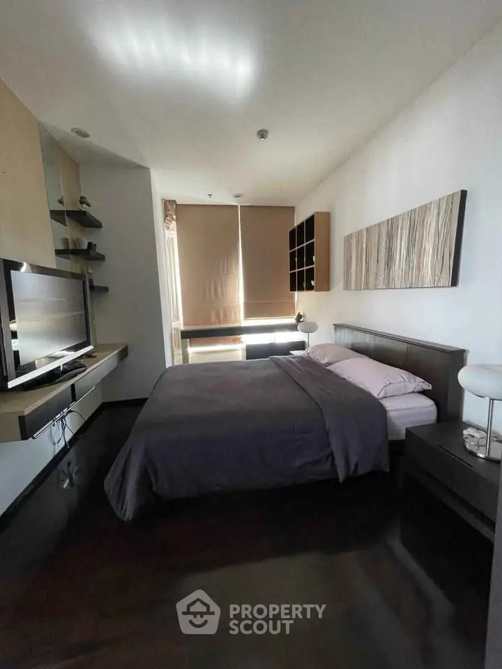 Modern bedroom with sleek design and natural light, featuring a comfortable bed and stylish decor.