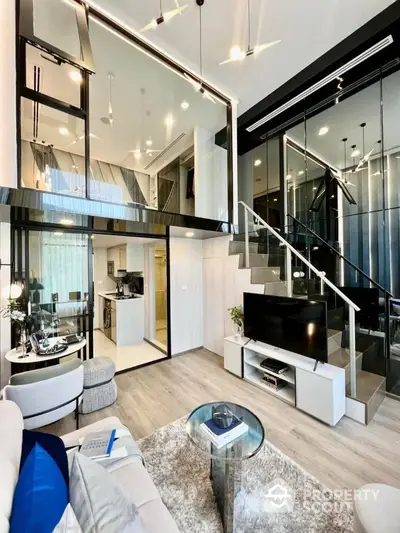 Luxurious duplex apartment with high ceilings, modern glass staircase, and sleek kitchen design, perfect for upscale urban living.