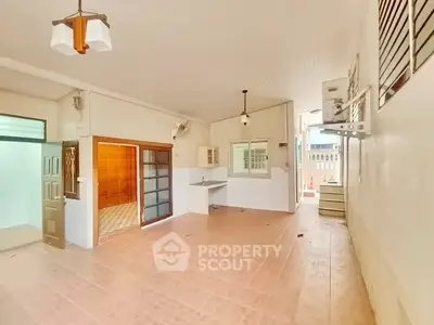 Spacious open-plan living area with tiled flooring and modern lighting, perfect for versatile home design.