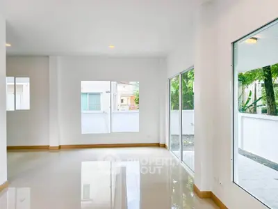 Spacious and bright living room with large windows and glossy floor tiles.