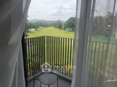 Stunning balcony view overlooking lush green golf course with mountains in the distance.