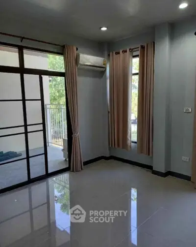 Spacious room with large windows and balcony access, perfect for natural light lovers.