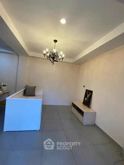 Modern living room with elegant chandelier and minimalist decor