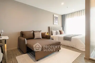 Modern bedroom with stylish decor and cozy seating area in a well-lit apartment.