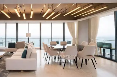 Luxurious open-plan living and dining area with panoramic ocean views and modern lighting.