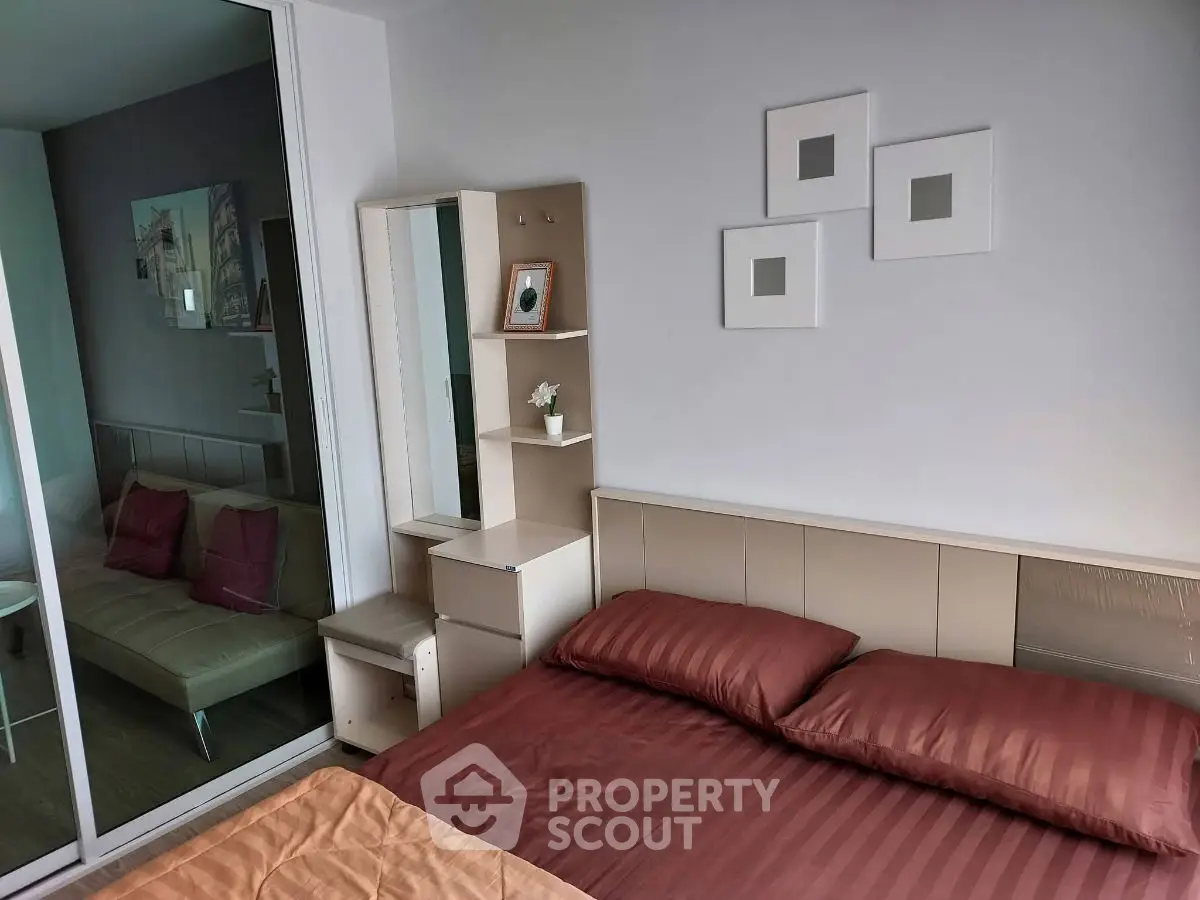 Modern bedroom with stylish decor and adjacent living area in a contemporary apartment.