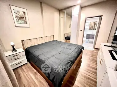 Cozy bedroom with modern decor and wooden flooring, featuring a comfortable bed and ample storage space.