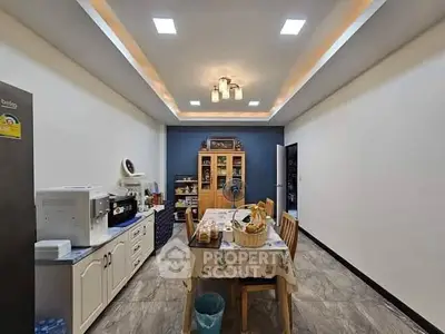 Spacious kitchen with modern lighting and dining area, perfect for family gatherings.