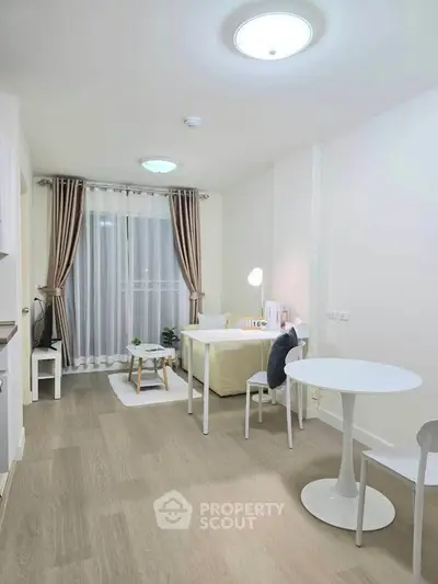 Modern living room with stylish decor and natural light, featuring a cozy seating area and elegant curtains.