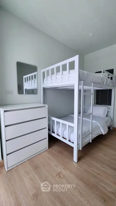 Modern bedroom with bunk beds and sleek dresser, perfect for maximizing space in a stylish home.