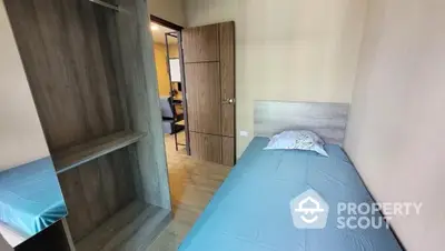 Cozy bedroom with single bed and wooden wardrobe, ideal for minimalist living.