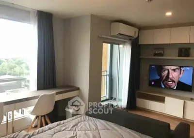 Modern bedroom with balcony, desk, and wall-mounted TV in a stylish apartment.
