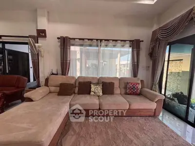 Spacious living room with plush sectional sofa and elegant curtains, perfect for relaxation and entertaining.