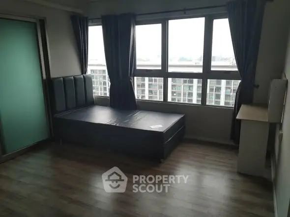 Spacious bedroom with large windows and city view